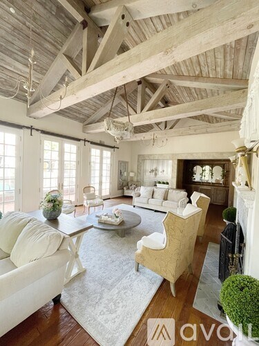 A living room with a white couch and a wooden ceiling.