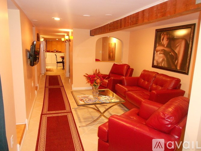 A hallway with red couches and a painting on the wall.