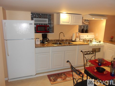 A kitchen with a white refrigerator and a sink.