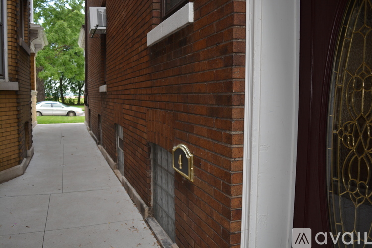 A red brick building with a white door and a window.