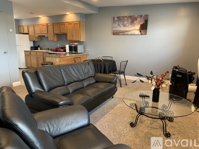 A black leather sofa and chairs in a living room.