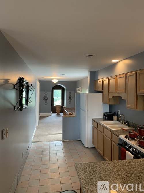 A kitchen with a white refrigerator and wooden cabinets.