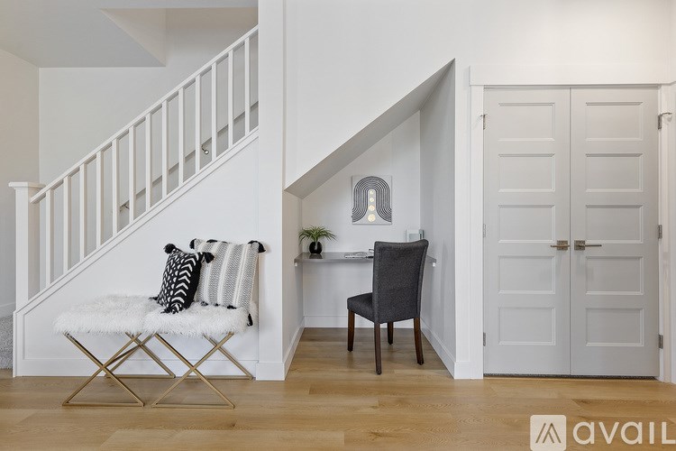 A chair is placed in a room with a white wall and a white staircase.