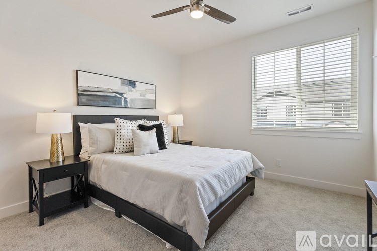 A bedroom with a bed, nightstand, and window.