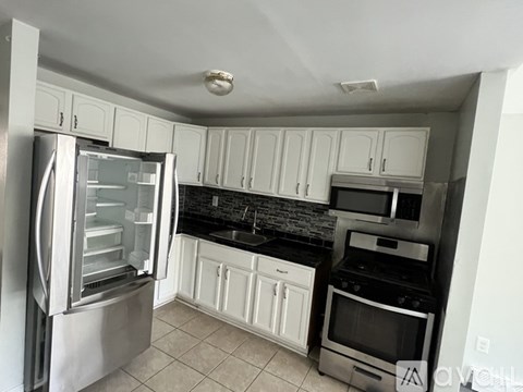 A kitchen with a refrigerator, oven, and microwave.