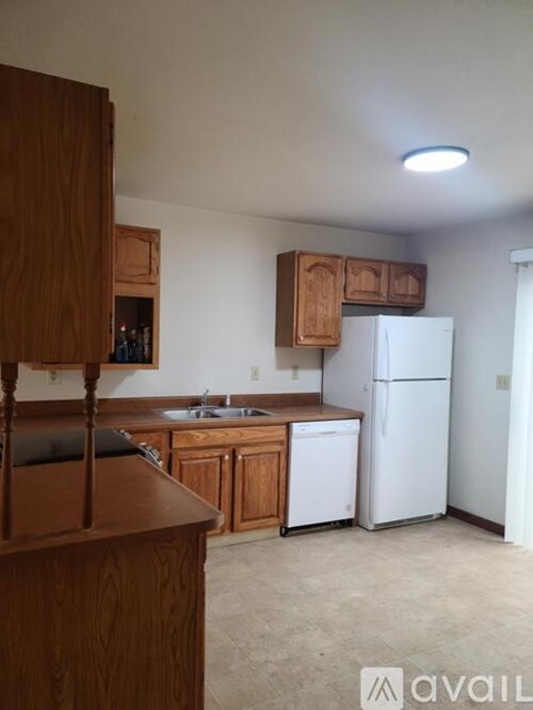 A kitchen with wooden cabinets and a white refrigerator.