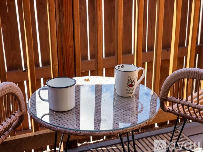 A white mug with a black handle is on a table with a glass top.