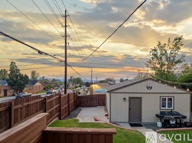 A backyard with a wooden fence and a small building.