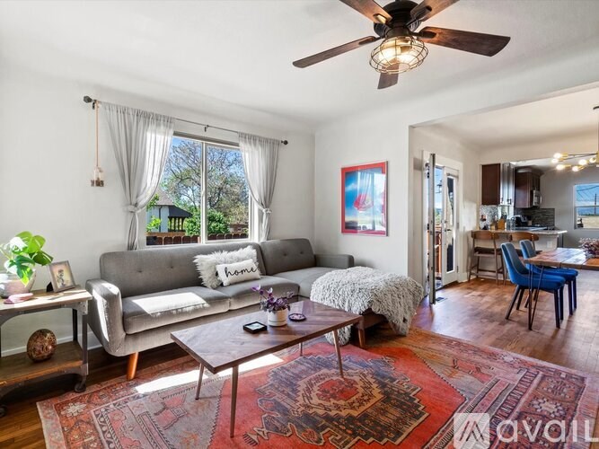 A living room with a grey couch, a coffee table, and a rug.