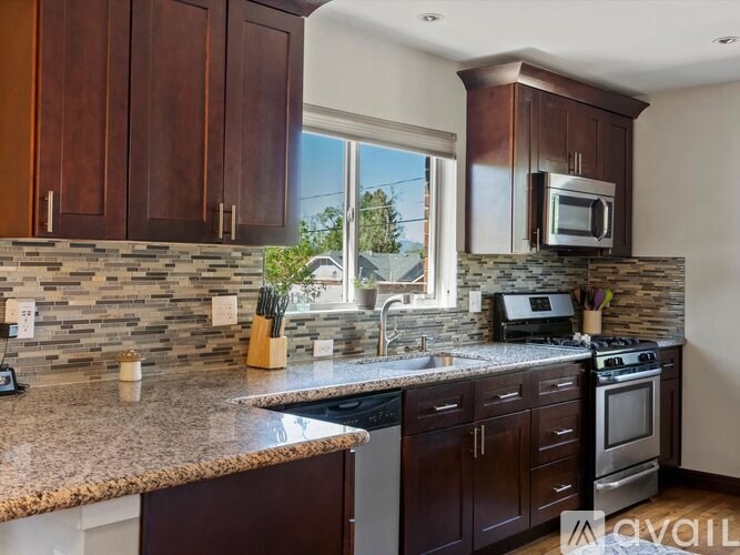A kitchen with brown cabinets and a granite countertop.
