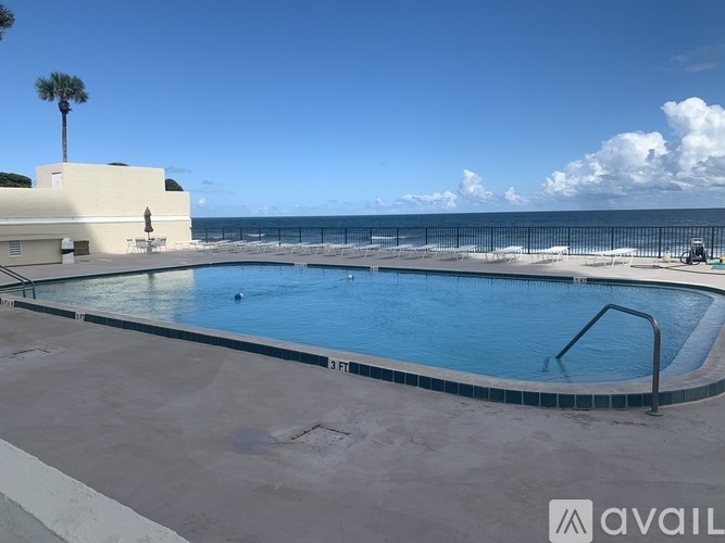 A pool with a view of the beach and the ocean.