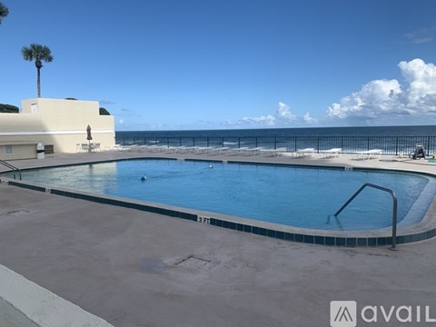 A pool with a view of the beach and the ocean.
