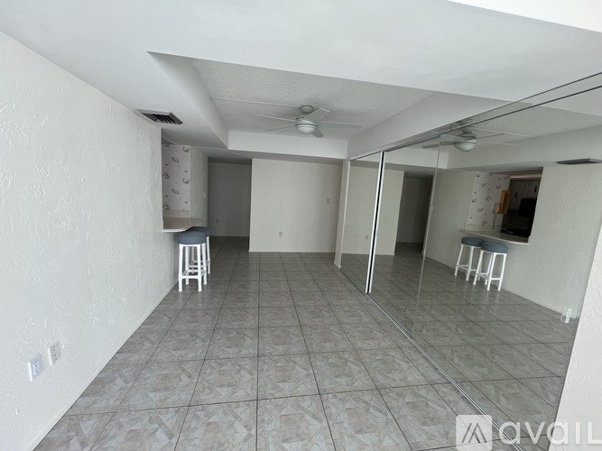 A spacious room with tiled flooring and a bar area.