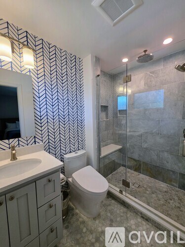 A bathroom with a toilet, sink, and shower.