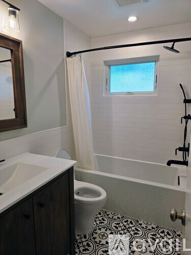 A bathroom with a black and white tiled floor.