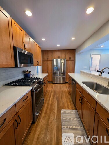 A kitchen with wooden cabinets and a stainless steel stove top.