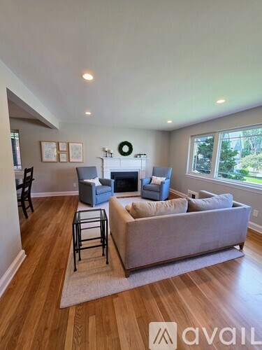 A living room with a grey couch and a fireplace.
