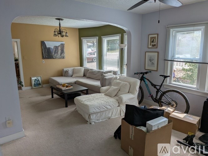 A living room with a couch, chair, and a bicycle.