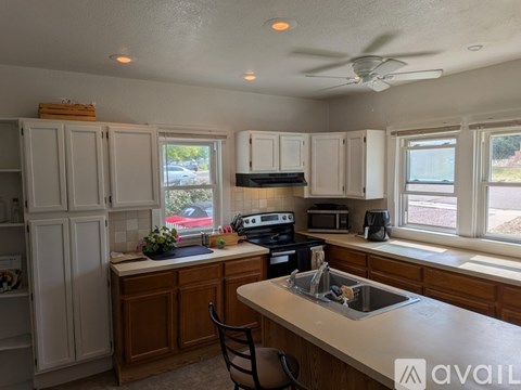 A kitchen with white cabinets and a wooden island.