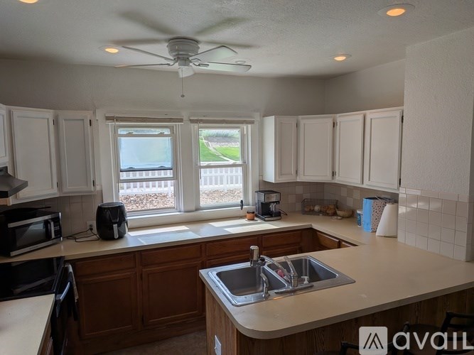 A kitchen with a sink, microwave, and a window.
