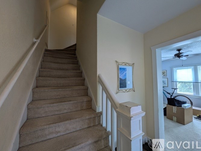 A staircase with a fan in the room.