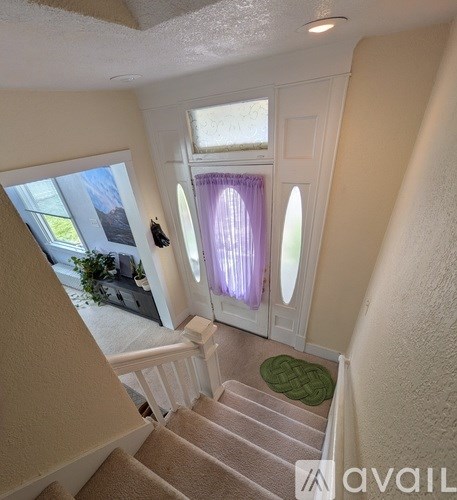 A staircase with a green rug on the floor.