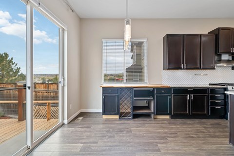 A kitchen with dark brown cabinets and a wooden floor.