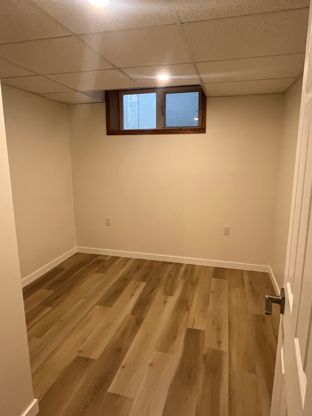 A room with a wooden floor and a window.