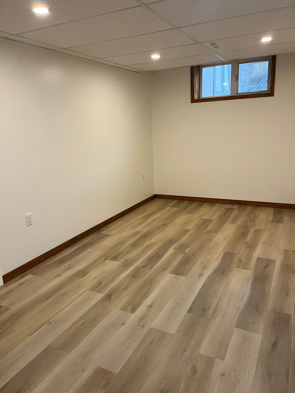 A room with wooden flooring and a window.