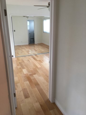 A room with a wooden floor and a mirror on the wall.