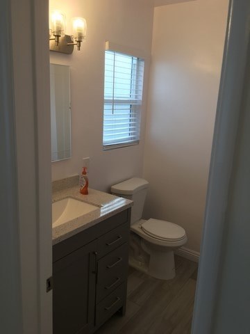 A bathroom with a toilet, sink, and mirror.