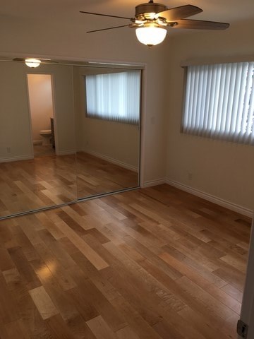A room with wooden flooring and a ceiling fan.