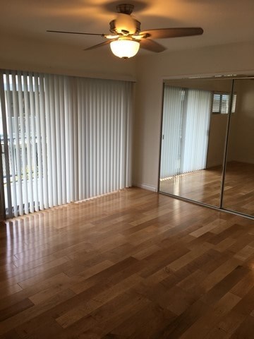 A room with wooden floors and a ceiling fan.
