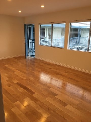 A room with a wooden floor and a black door.