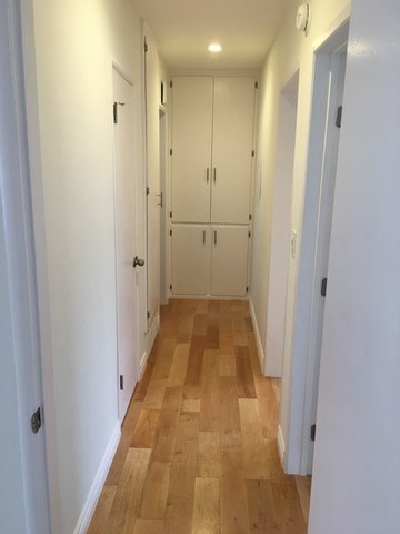 A long hallway with white doors and wooden floors.