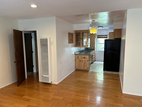 A kitchen with wooden floors and white walls.