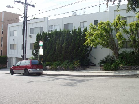 A red van is parked on the side of a street.