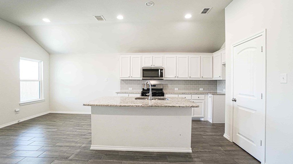 A kitchen with a white island and cabinets.