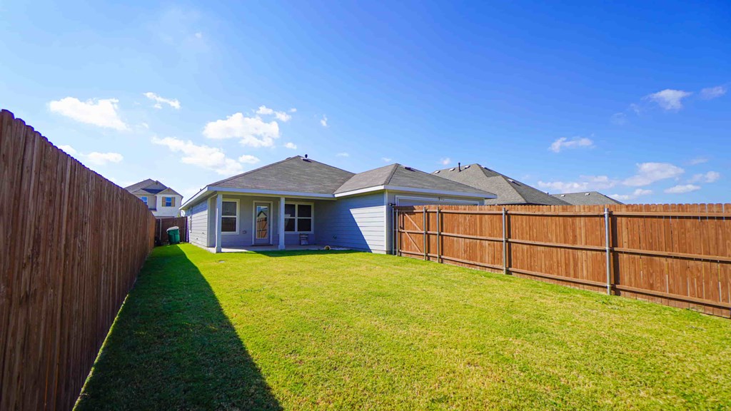 A house with a blue roof and a brown fence.