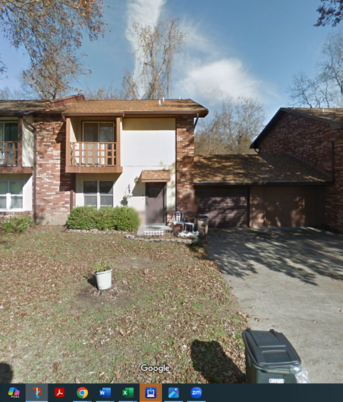 A Google image of a house with a brown roof and a white garage door.