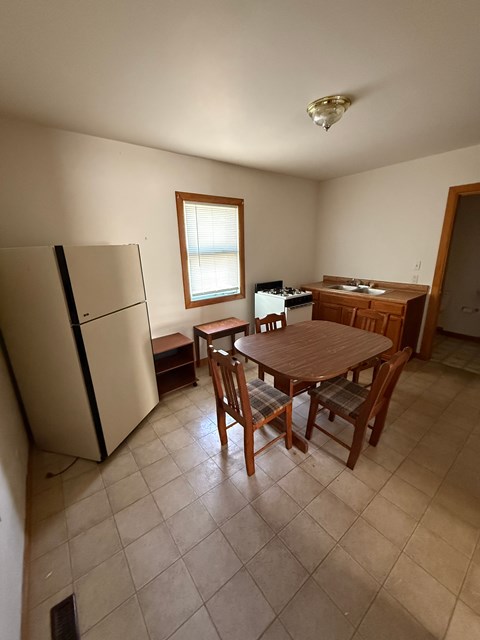 A kitchen with a table and chairs.