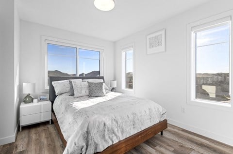 A bedroom with a large bed and a view of the mountains outside the window.