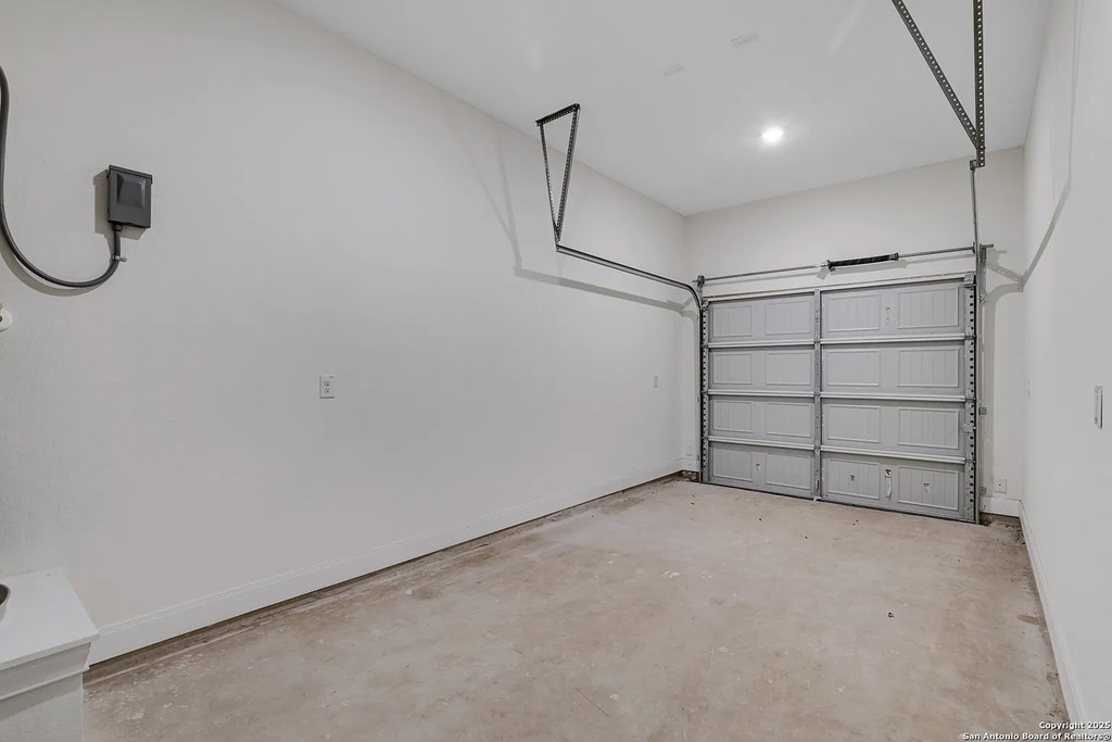 A garage with a white wall and a white door.