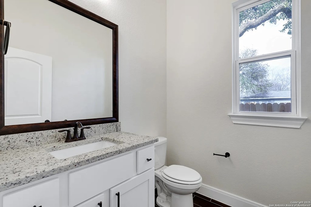 A white toilet sits next to a sink in a bathroom.