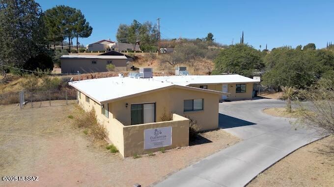 A building with a sign that reads "Clifton" is surrounded by a dirt road and vegetation.