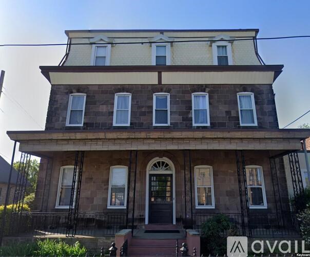A two-story house with a front porch and a sign that says "available".