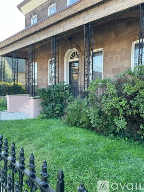 A house with a black iron fence in front.