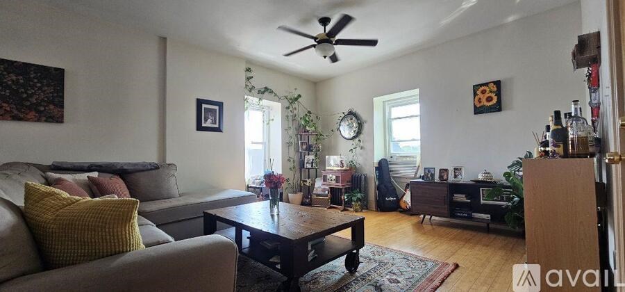 A white bathtub sits in a bathroom with a wooden toilet.