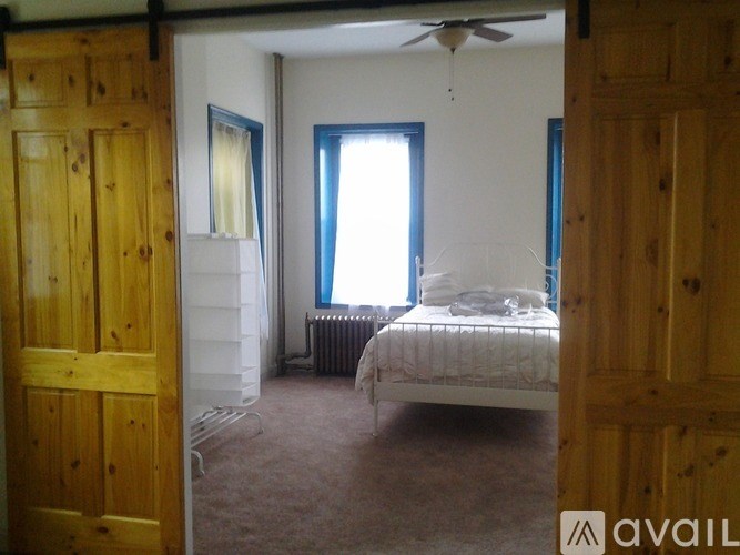 A bedroom with a bed, dresser, and window.