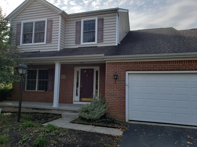 A house with a red door and a garage door.